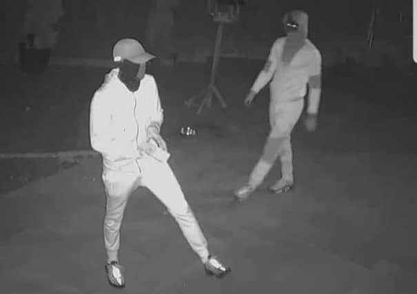 CCTV pictures of two people in tracksuits and ski masks
