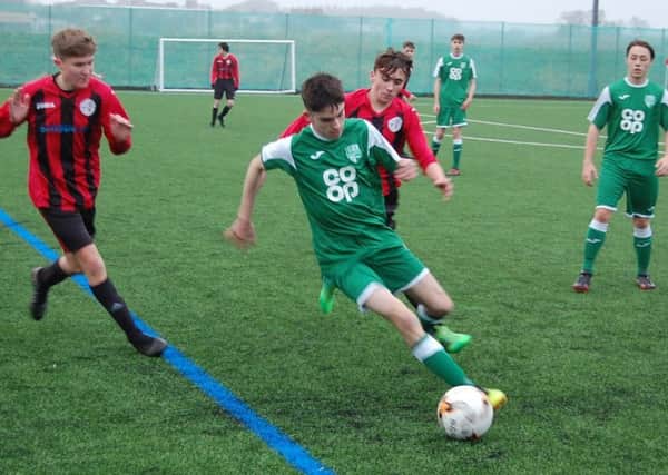 Archie Watson of Thornton Hibs under 19s is closed down by Grainger Smith and Dylan King of Rosyth Fury