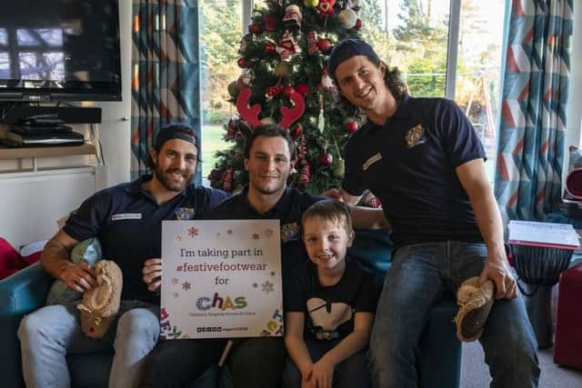 Taking time out...to visit Rachel House is a privilege for the players, pictured here with Archie Anderson (8) who will be attending his first game in January.