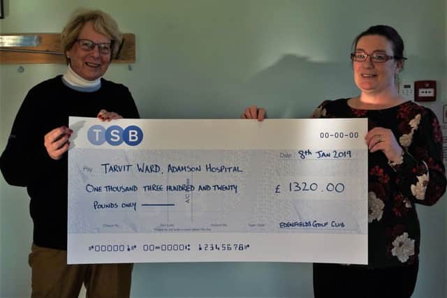 Mary Russell presenting the cheque to staff nurse Siri Sinclair.