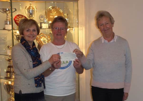 Ann Robertson and Rhoda Wilson, captain and vice-captain of St Regulus Ladies GC presenting the cheque to Gwenyth Mitchell (centre).