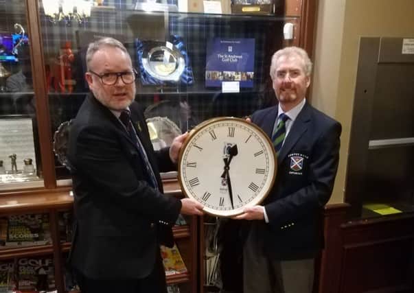 St Andrews Club captain David Edgar receives the clock from Joe Noble, captain of the New Golf Club.