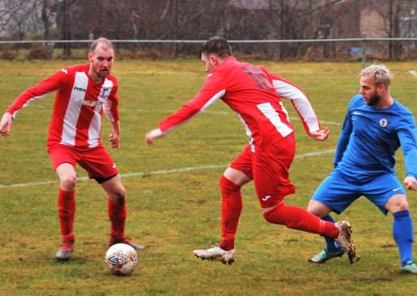 Newburgh, in red and white, work hard in the midfield. Pic by Graham Strachan.
