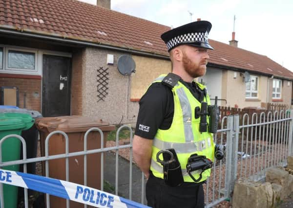 Aan officer stands outside the Alison Street home of murdered Kirkcaldy man Kevin Byrne. (pic George McLuskie).