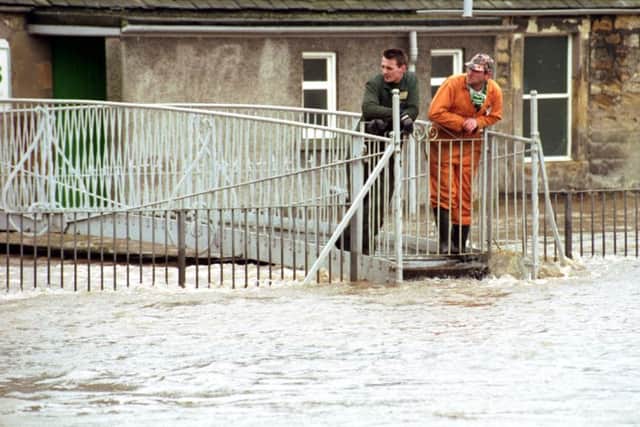Workmen in Cupar watch the water rising after heavy rain causes flooding in the spring of 1992.
