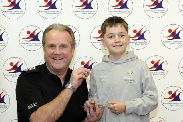 John Buist of Flyers Trampoline Club receives the Junior Award trophy from Chief Inspector Tom Brown. Runners-up were Tiyan Shek (Fife Dance Dreams) and Elyse Milne (Dardas Diamonds baton twirlers)
