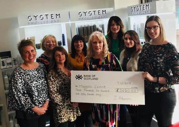 Staff at Janet Adamson Hairdressing proudly displaying the cheque for the £3650 raised.