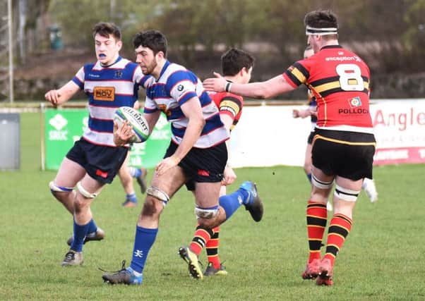 Jamie Thomson runs through Stewart's Melville players supported by Will Howley. Pic by Chris Reekie.