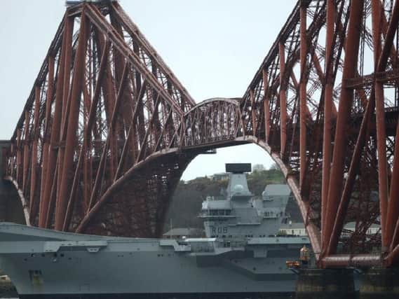The suppercarrier passes under the Forth Bridge.