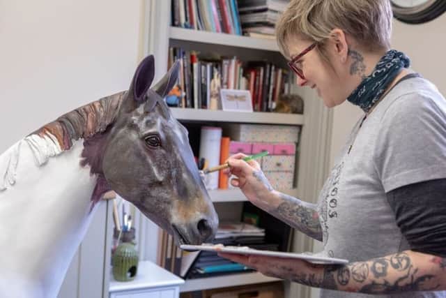 Montrose-based tattoo artist, Judi Milne, who is painting one of the sculptures.