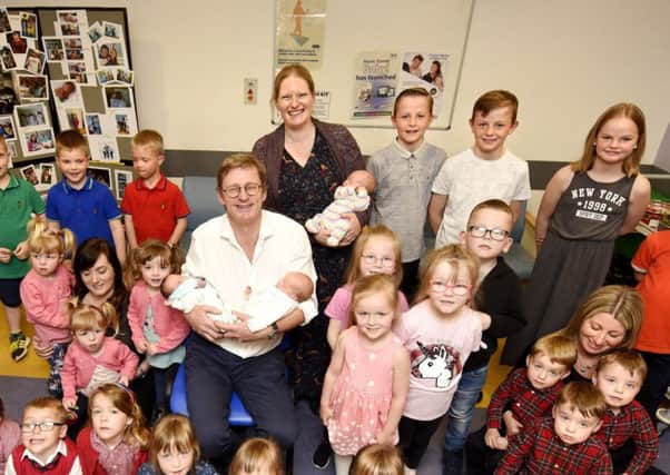Graham Tydeman surrounded by the  triplets he helped to deliver. Pic:  Fife Photo Agency.