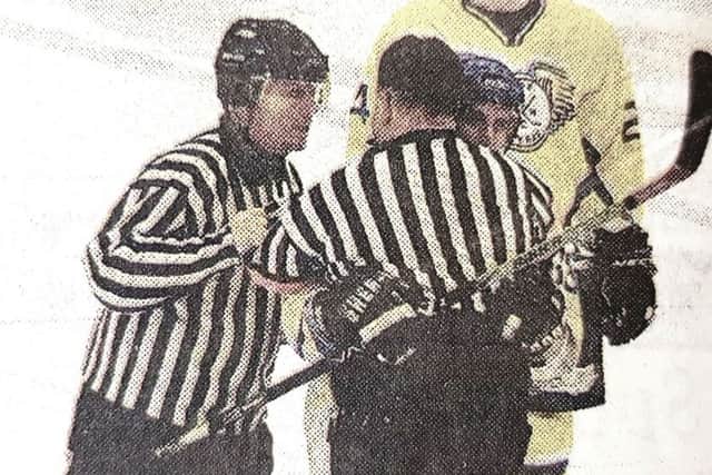 Shaken referee Alan Craig is helped off the ice