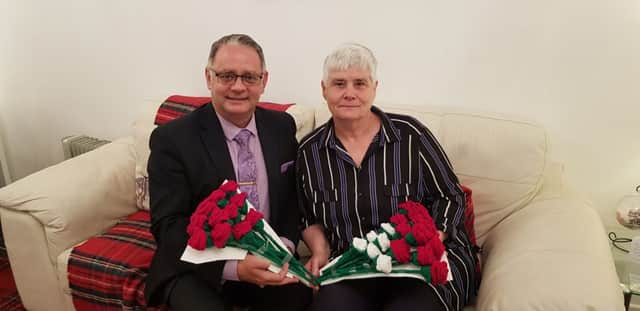 Ian Johnston with Anne Simms and her knitted roses which will be given to bereaved families