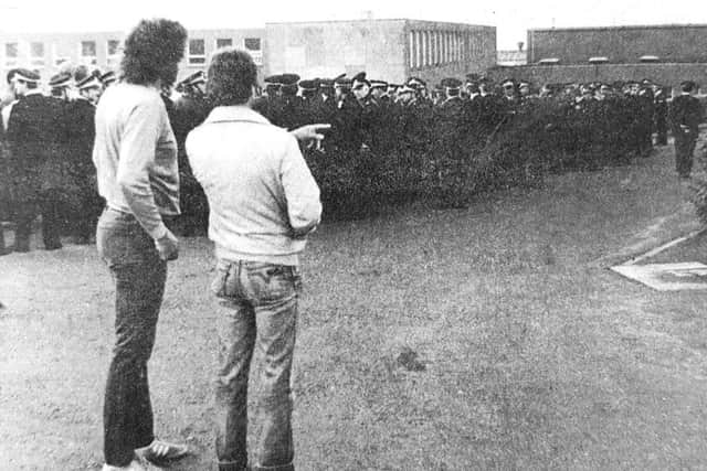 Police form a human cordon around two miners crossing the picket line at the Frances Colliery.