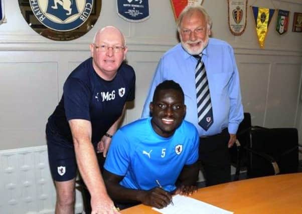 Fernandy Mendy signs for Raith Rovers with manager John McGlynn and chairman Bill Clark (Pic by Tony Fimister)