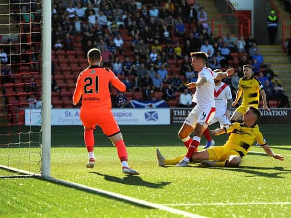Grant Anderson slides in to score Raith's winning goal in Airdrie. Pic: Fife Photo Agency