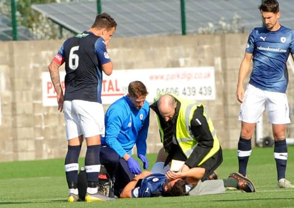 Raith captain Kyle Benedictus shows concern for Ross Matthews as he gets attention from sports therapist Iain Williamson and the East Fife club doctor - credit- Fife Photo Agency