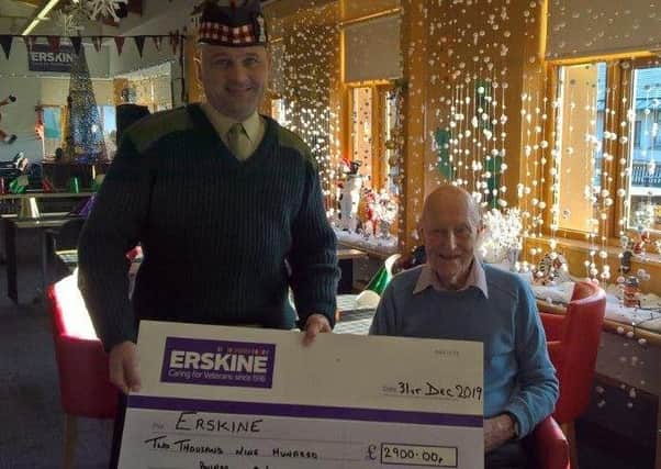 Sergeant Major Lee Penrice presents a cheque to 104 -year-old RAF veteran John Haswell Young, a resident of the Erkine home in Bishopton