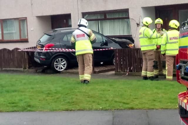 Emergency services are on the scene in Kirkcaldy after a car collided with a property in Lindores Drive. Pic: Scott McCartney.